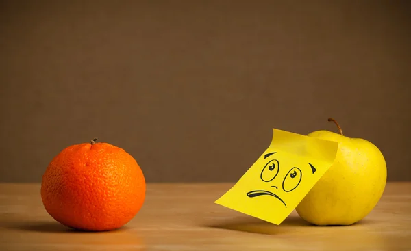 Maçã com nota post-it pegajoso olhando tristemente para laranja — Fotografia de Stock