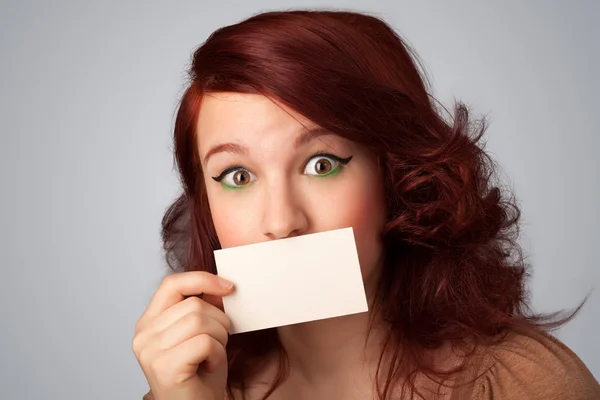 Menina bonito segurando cartão branco na frente de seus lábios com cópia spac — Fotografia de Stock