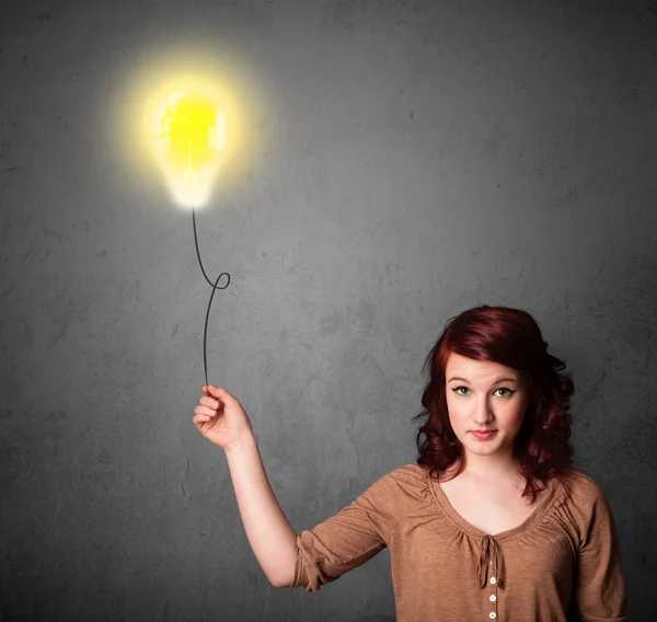 Woman holding a lightbulb balloon — Stock Photo, Image