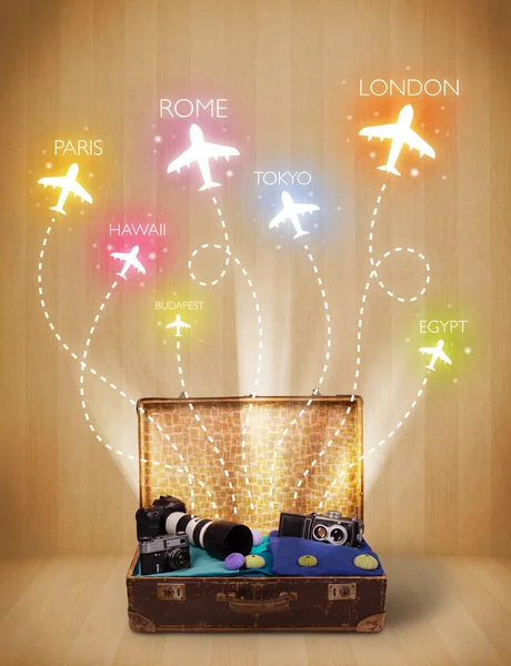 Travel bag with clothes and colorful planes flying out — Stock Photo, Image