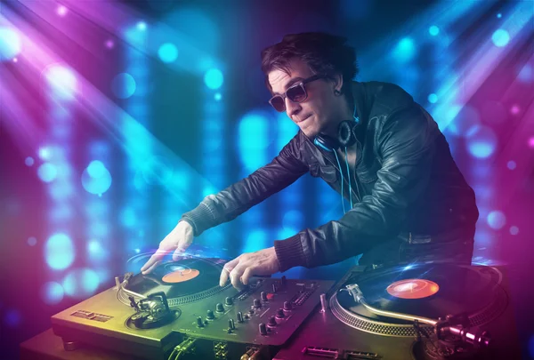 Dj mixing music in a club with blue and purple lights — Stock Photo, Image