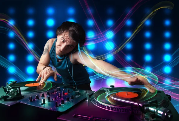 Jovem Dj misturando registros com luzes coloridas — Fotografia de Stock