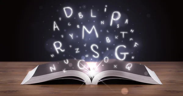 Open book with glowing letters flying out — Stock Photo, Image