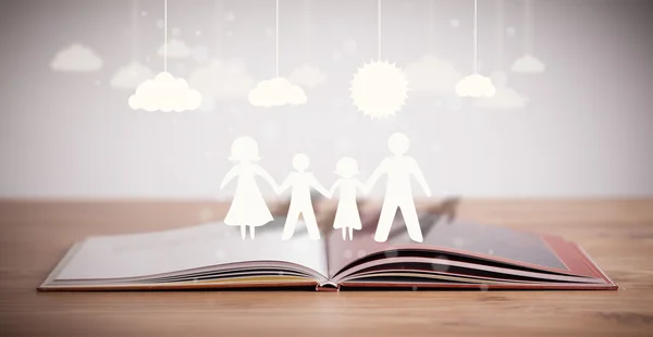 Tekturowe figury rodziny na otwartej książce — Zdjęcie stockowe