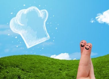 Mutlu gülen yüzlü parmaklar aşçı şapkasının resmine bakıyor.