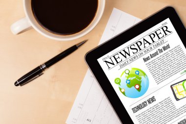 Tablet bilgisayarı haberleri ekranda bir fincan kahveyle sunar.