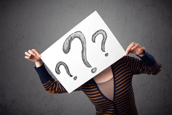 Woman holding paper with drawed question marks in front of her h — Stock Photo, Image
