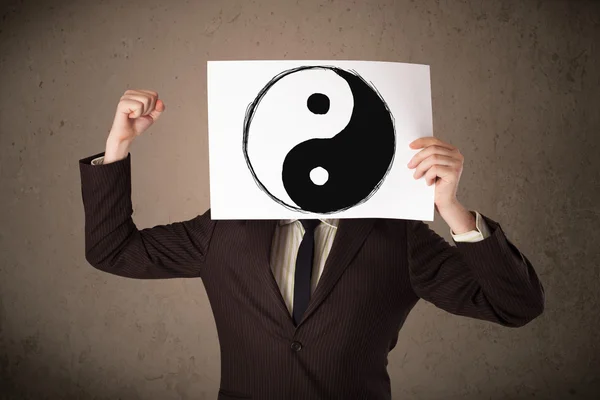 Uomo d'affari che tiene un giornale con uno yin-yang sopra davanti a ciao — Foto Stock