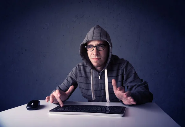 Hacker trabalhando com teclado em fundo azul — Fotografia de Stock