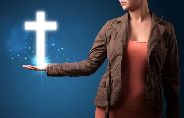 Gloeiende kruis in de hand van een vrouw — Stockfoto