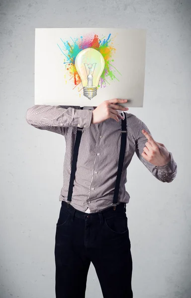 Επιχειρηματίας που κρατά ένα χαρτόνι με πιτσιλιές χρωμάτων και lightbul — Φωτογραφία Αρχείου