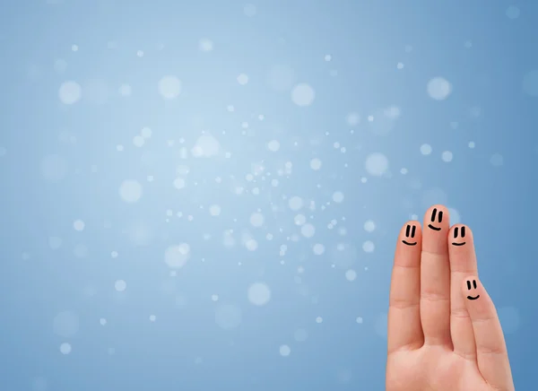 Happy finger smileys with empty blue bokeh background — Stock Photo, Image