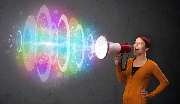 Junges Mädchen schreit in einen Lautsprecher und bunten Energiestrahl com — Stockfoto