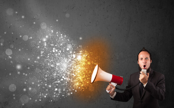 Guy shouting into megaphone and glowing energy particles explode