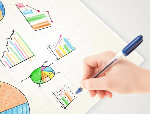 Business person drawing colorful graphs and icons on paper — Stock Photo, Image