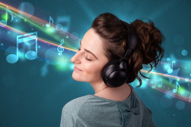 Kulaklıkla müzik dinleyen genç bir kadın.