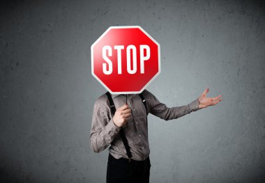 İşadamı elinde dur levhası tutuyor.