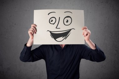 empresario sosteniendo una cartulina con cara sonriente en él en frente