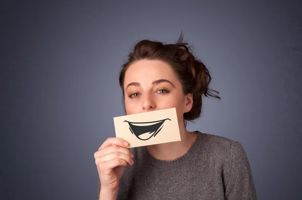 Feliz bonito menina segurando papel com engraçado smiley desenho — Fotografia de Stock