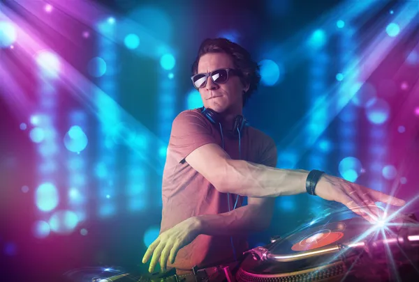 DJ mixování hudby v klubu s modrým a fialovým světlem — Stock fotografie