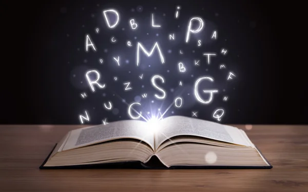 Libro abierto con letras brillantes volando — Foto de Stock