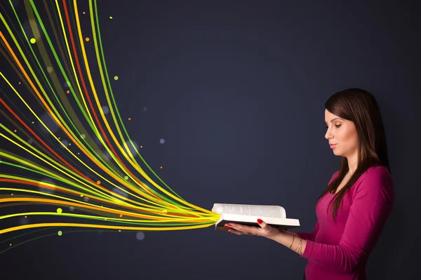 Mujer bastante joven leyendo un libro, mientras que las líneas de colores vienen —  Fotos de Stock