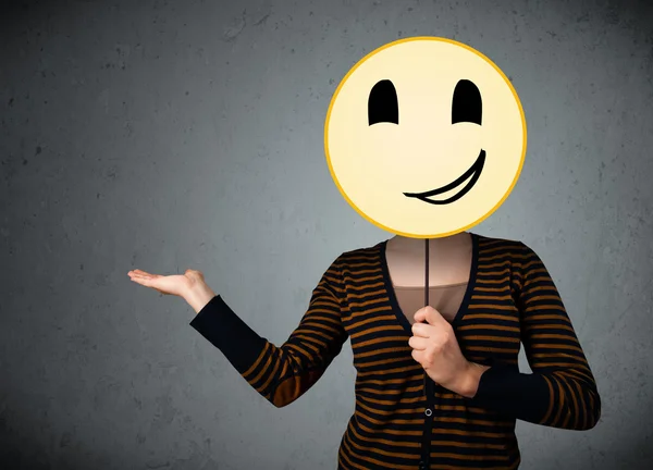 Junge Frau mit einem Smiley-Emoticon — Stockfoto