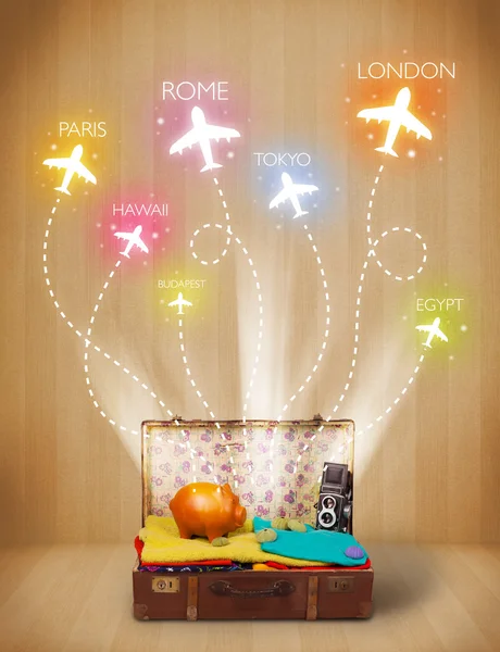 Travel bag with clothes and colorful planes flying out — Stock Photo, Image