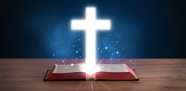 Abra a Bíblia sagrada com cruz brilhante no meio — Fotografia de Stock