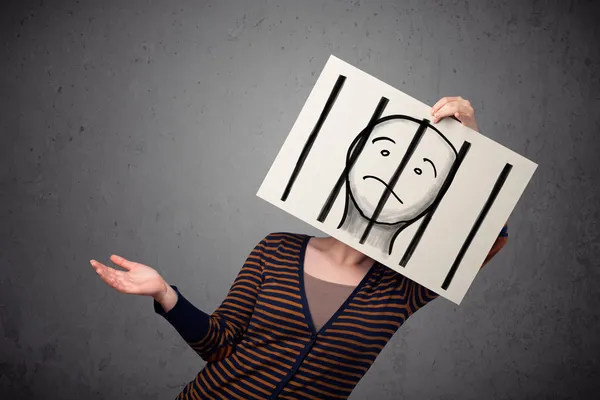 Woman holding a paper with a prisoner behind the bars on it in f — Stock Photo, Image