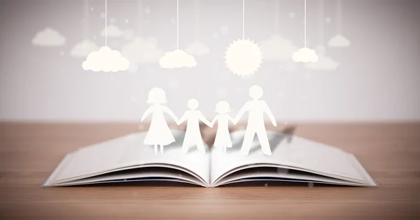 Cardboard figures of the family on opened book — Stock Photo, Image