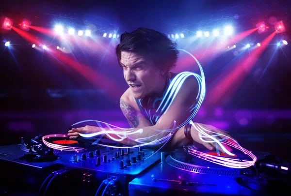 Disc jockey playing music with light beam effects on stage — Stock Photo, Image