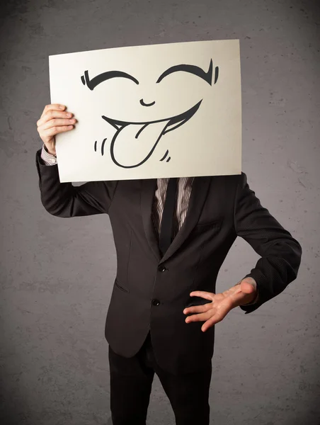 Empresário segurando um papel com cara sorridente engraçado na frente de h — Fotografia de Stock