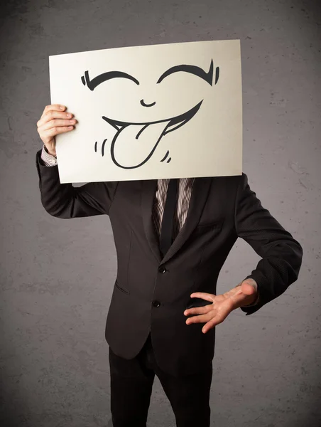 Zakenman met een papier met grappige smileygezicht voor h — Stockfoto