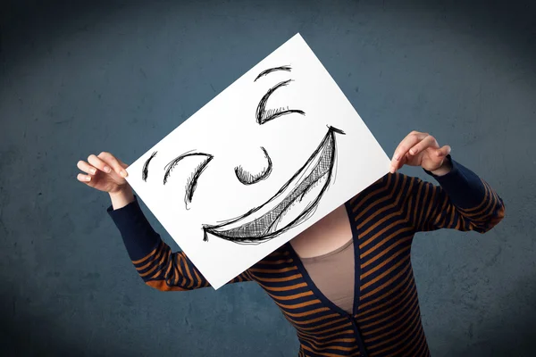 Woman with drawed smiley face on a paper in front of her head — Stock Photo, Image