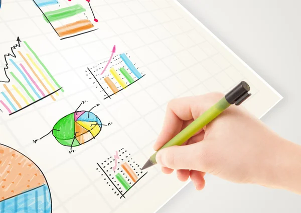 Persona de negocios dibujo coloridos gráficos e iconos en papel —  Fotos de Stock