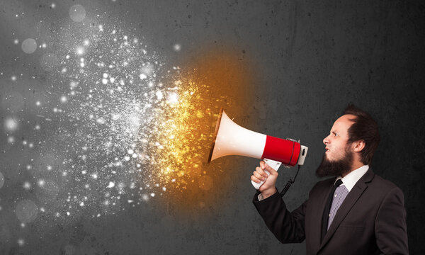 Парень, кричащий в мегафон и пылающие частицы энергии взрываются