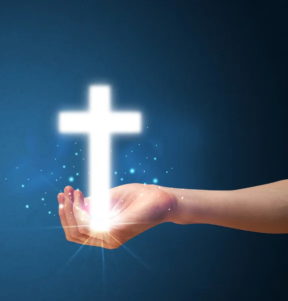 Glowing cross in the hand of a woman — Stock Photo, Image