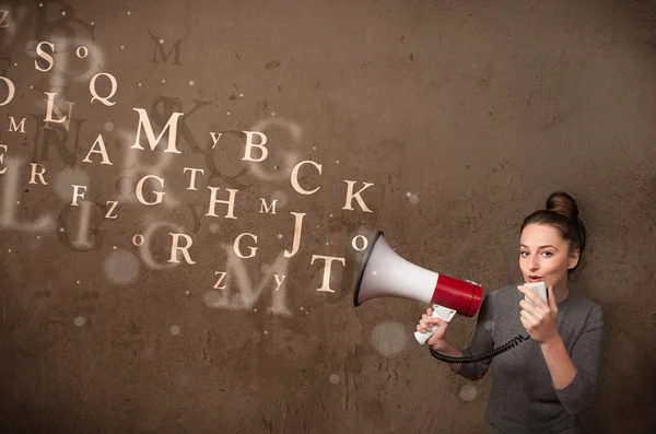 Young girl shouting into megaphone and text come out — Stock Photo, Image