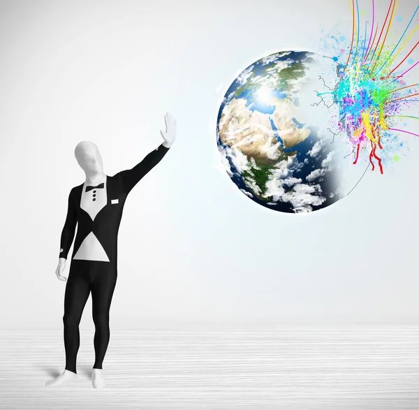 Funny man in body suit looking at colorful splatter earth — Stock Photo, Image