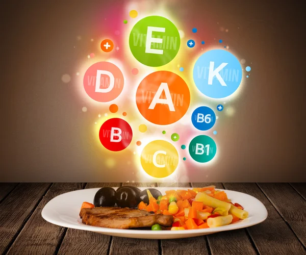 Food plate with delicious meal and healthy vitamin symbols — Stock Photo, Image