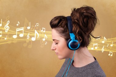 Kulaklıklı genç bir kadın müzik dinliyor.