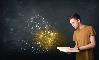 Genç adam sihirli bir kitap okuyor.