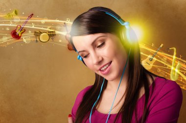 Kulaklıklı genç bir kadın müzik dinliyor.