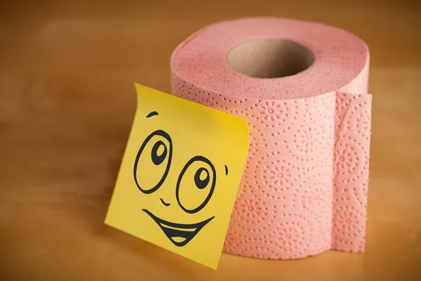 Post-it note with smiley face sticked on toilet paper — Stock Photo, Image