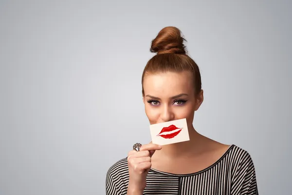 Jolie jolie femme tenant la carte avec marque de rouge à lèvres baiser — Photo