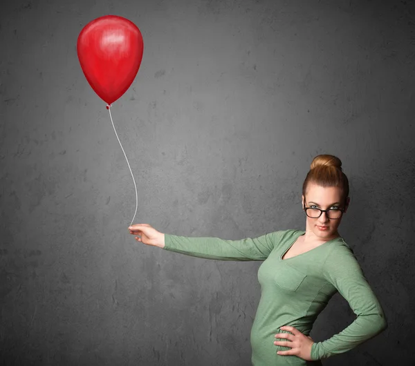 Mujer sosteniendo un globo rojo — Foto de Stock