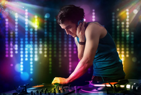 Dj tocando canciones en una discoteca con espectáculo de luz — Foto de Stock