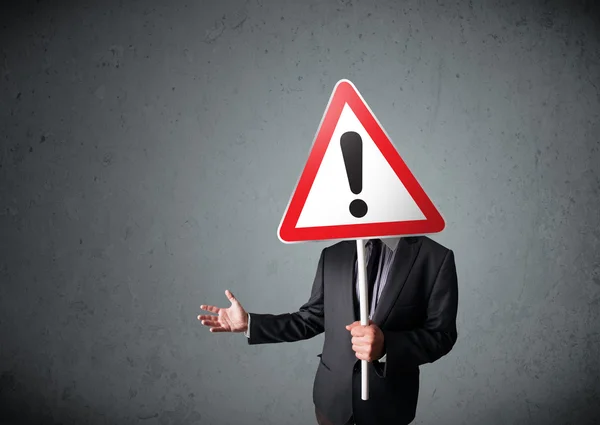 Businessman holding an exclamation road sign — Stock Photo, Image