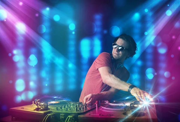 Dj mixing music in a club with blue and purple lights — Stock Photo, Image